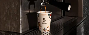 Coffee cup with custom branded packaging design showcasing visual identity